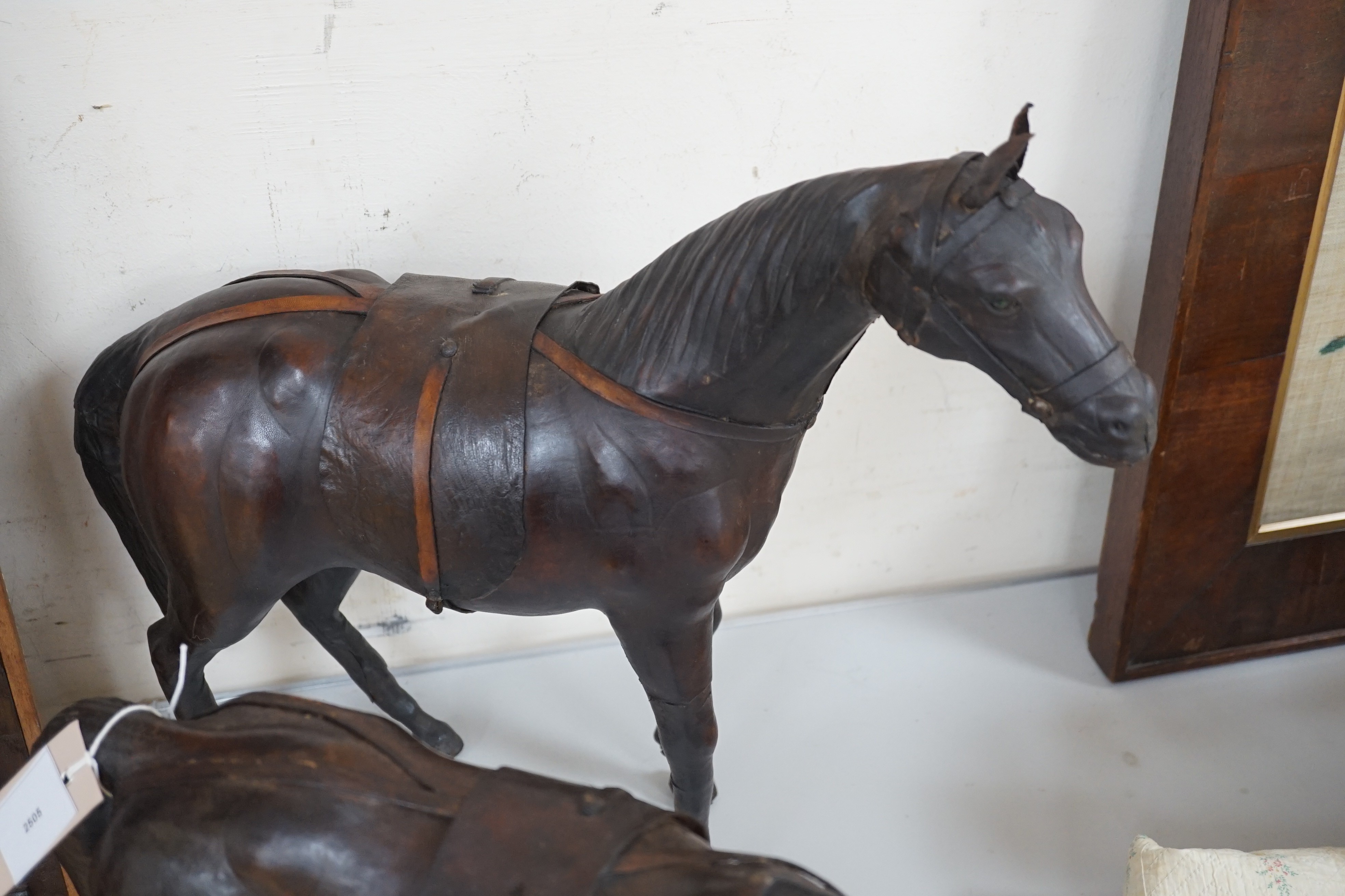 Two finely modelled horses made from brown leather, tallest 49 cms high